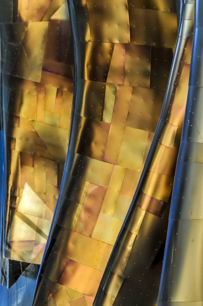 pexels-photo-10115277 Close-up of abstract golden metal panels with reflections and textures.